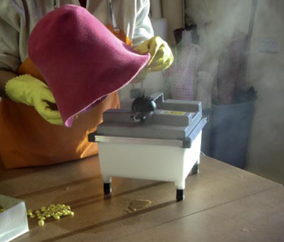 Making hats, steaming the felt.